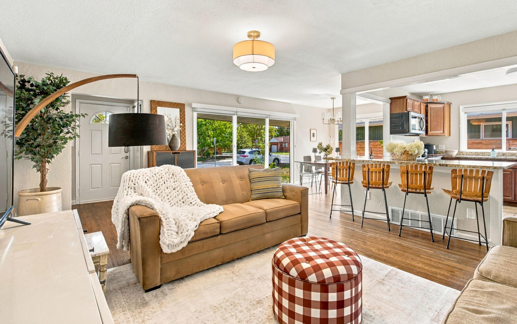 Bright furnished living room with open kitchen and dining area in Denver home